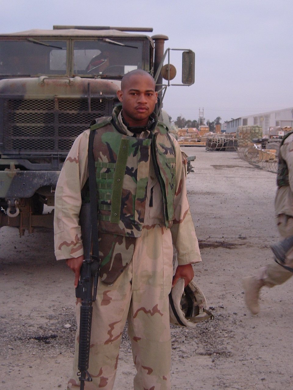 With his rifle beside a company truck, March 25, 2004.