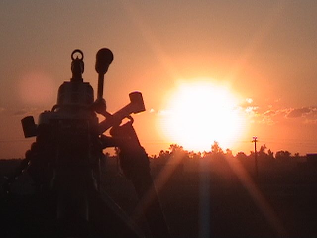 Sunset behind a mounted machine gun, March 2004.